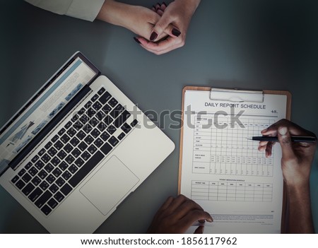 Aerial view of doctor writing patient daily report checklist