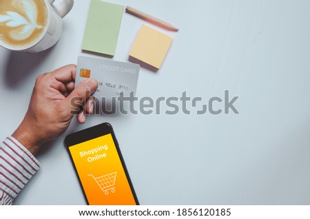 Business man holding credit card.Online shopping, business marketing through electronic payment with smartphone.Top view and copy space.