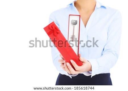 A midsection of a woman handing a red box with a key over white background