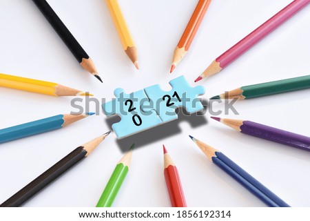 New year 2021 on blue puzzle with colored pencils isolated on white background.  Business teamwork concept and synergy connection idea