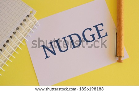 White paper with text Nudge on yellow background. Pushing gently concept Friendly Reminder Sign. Royalty-Free Stock Photo #1856198188