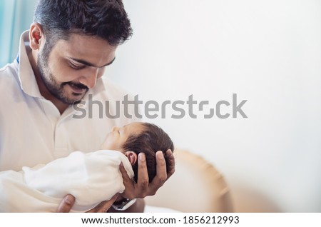 Closeup portrait of young asian Indian father holding his newborn baby with copy space. Healthcare and medical daycare nursery love lifestyle together single dad father’s day holiday concept Royalty-Free Stock Photo #1856212993