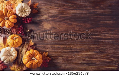 Thanksgiving background decoration from dry leaves and pumpkin on old wooden background. Flat lay, top view for Autumn, fall, Thanksgiving concept.