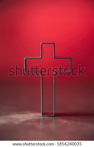 Christian cross on red background with soft bokeh lights background. Copy space. Banner. Church worship, salvation concept. Faith symbol in Jesus Christ. Holy cross for good friday, Easter day.