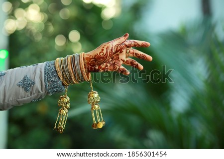 The bride's hand is full of bracelets and henna