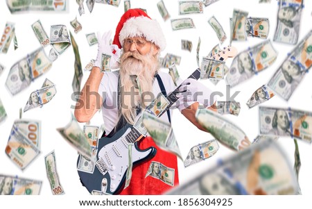 Old senior man with grey hair and long beard wearing santa claus costume playing electric guitar doing ok sign with fingers, smiling friendly gesturing excellent symbol