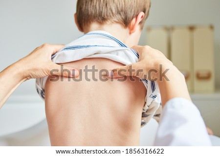 Chiropractor or osteopath does acupressure on back of child with back pain Royalty-Free Stock Photo #1856316622