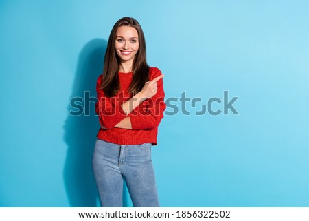 Photo of positive girl point index finger copyspace wear pullover isolated over blue color background