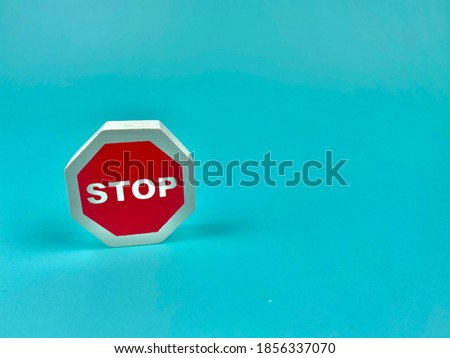 The red sign with the word STOP inside is on the front. Blue background
