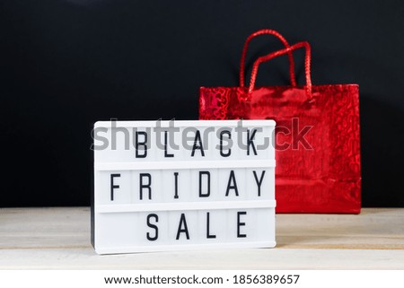 Black Friday sale. Red shopping bag and lightbox on dark background. Banner for advertising.
