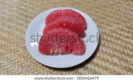 Pink grapefruit placed on a plate.
