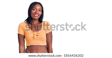 Young african american woman wearing casual clothes looking positive and happy standing and smiling with a confident smile showing teeth 