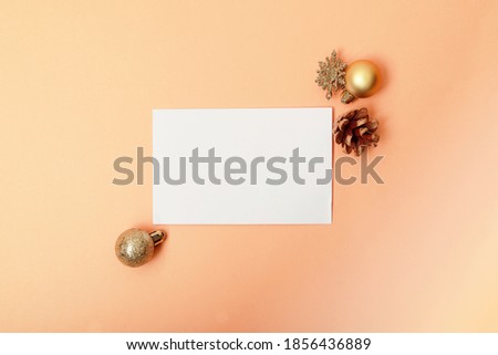 white envelope on orange background and gold Christmas decorations