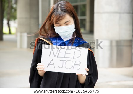 Sad, hopeless, jobless Asian college graduate student woman wearing face mask, concept of being unemployed due to job cut, employment disruption after COVID-19 pandemic led economic recession