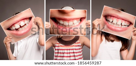 group of children holding picture of mouth smiling showing her teeth. Dentist concept