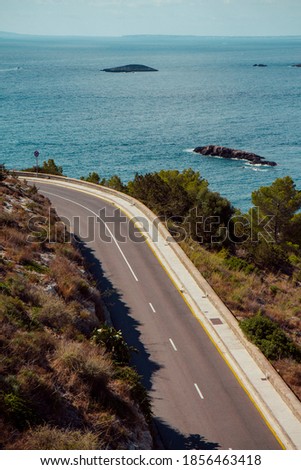 Beautiful road through the mountains with ocean in the background