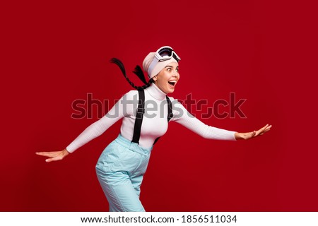 Photo of young pretty happy positive shocked excited girl skiing fast winter vacation isolated on red color background