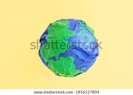 Ecology concept, environment, plastic free, saving the planet. Model of planet wrapped in a plastic bag. The seas and continents are painted with paint. Shriveled planet Earth. Minimalism, copy space. Royalty-Free Stock Photo #1856527804