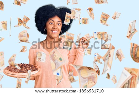 Young african american girl holding italian pizza smiling happy pointing with hand and finger to the side