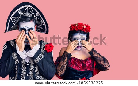Young couple wearing mexican day of the dead costume over background rubbing eyes for fatigue and headache, sleepy and tired expression. vision problem 