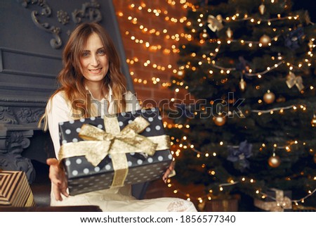 Woman at home. Girl in a white dress. Lady near christmas tree.