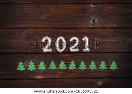 The wooden Christmas background is decorated with festive decor, lanterns, snowflakes and branches of the Christmas tree. Christmas card. Winter holiday season. Happy New Year.