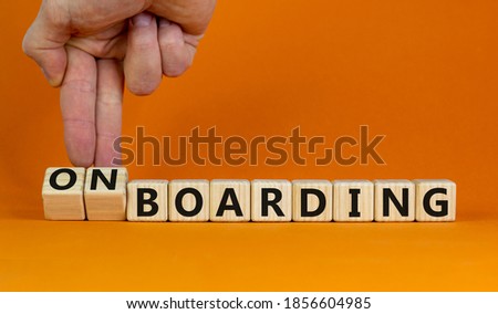 Hand flips cubes and changes the expression 'boarding' to 'onboarding'. Beautiful orange background. Business concept. Copy space.