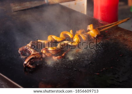Cumi bakar or grilled squid is Indonesian street food. selective focus. grainy picture
