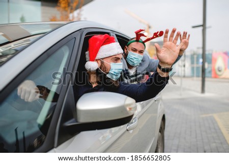 Friends wearing a protective face mask in the car. Holidays during epidemic. 