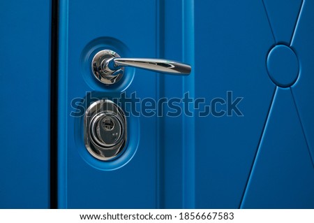 chrome handle in steel color in metal entrance door in blue color and modern finish Royalty-Free Stock Photo #1856667583