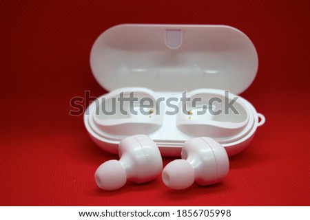 White wireless headphones Isolated from the red background