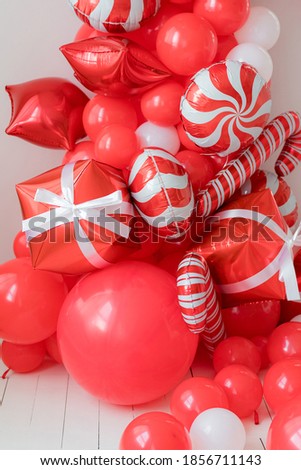Red and white Christmas balloon decorations. Christmas balloon sticks and gifts