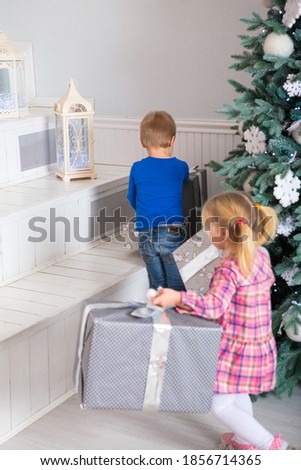 little boy and girl open new year gifts