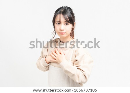A young woman who puts her hand on her chest taken in the studio