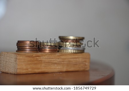 Three stacks of Euro coins on the wooden block, reminding growing diagram. Business profit growth concept