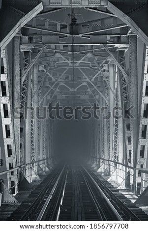 Night, illuminated railway bridge in black and white tones