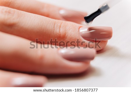 Manicure process. Manicurist paints fingernails. Nail polish. Royalty-Free Stock Photo #1856807377