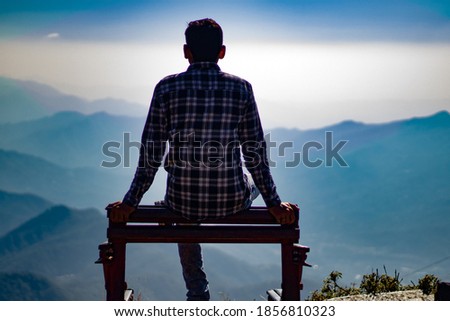 Picture of boy sitting on top of mountain. bokeh f1.8. Himachal pradesh India