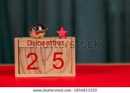 Photo of a wooden calendar on a red background, christmas, wooden toys, place for text