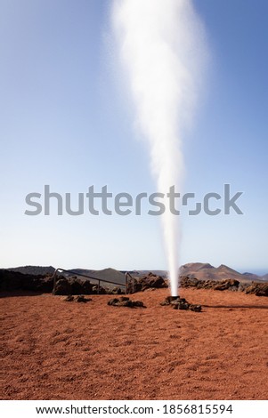 Artificial volcanic vapor geyser ejecting water in Timanfaya National Park, Lanzarote. Tourism attraction, travel destination concepts Royalty-Free Stock Photo #1856815594