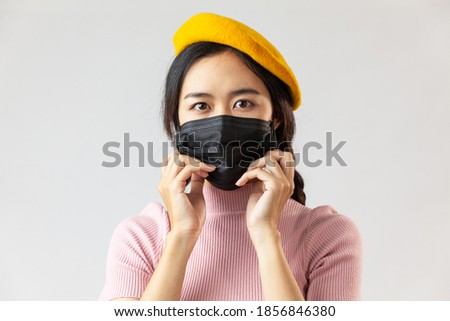 Asian woman black hair wearing charcoal face mask for protection of corona virus covid-19 and pm 2.5 with white background.