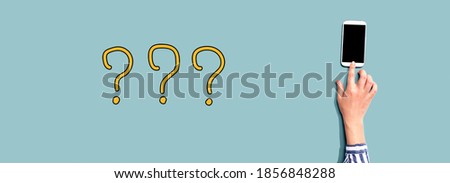 Question marks with person using a smartphone