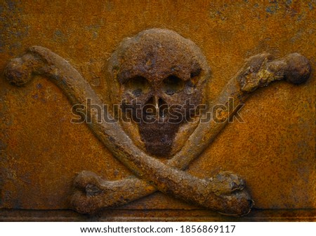 Rusty human skull with crossed bones cast from iron Danger and death symbol.