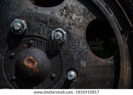 Metal sheet, garage part, bolted, carving wheel disc, nuts, screws, traces of rust and old paint and metal corrosion, cracks