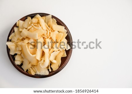 Coconut chips in bowl, space for copy text. Cocos nucifera. Royalty-Free Stock Photo #1856926414