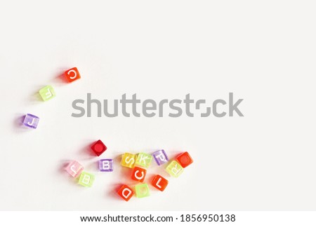 Different colorful letters on table. High quality photo. Cube shape. Typography design. Message broken. Label concept. Constructor for lettering. Copyspace. Light grey background