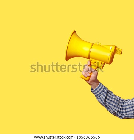 The man's hand holds a yellow megaphone. copy space. Schoblon for design
