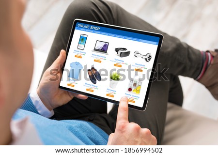 Man shopping at online store on his tablet computer Royalty-Free Stock Photo #1856994502