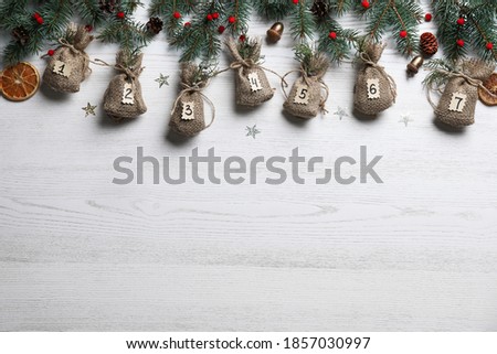 New Year advent calendar with gifts and Christmas decor on white wooden background, flat lay. Space for text