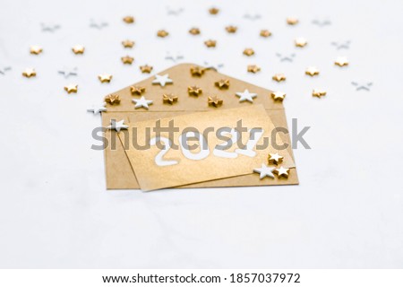 Postcard with gold stars, sequins and the number 2021. holiday layout. Christmas concept. Flat bed, top view.